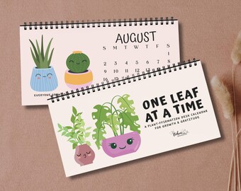 May include: Two spiral-bound desk calendars featuring plant illustrations. The top calendar displays August with a cactus and a succulent in pots. The bottom calendar reads "ONE LEAF AT A TIME" with plant graphics.