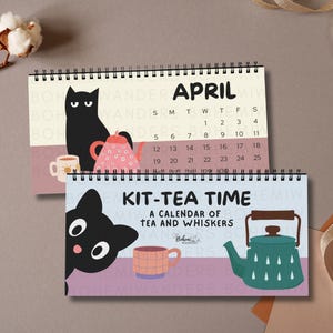 Könnte beinhalten: Zwei Spiral-Kalender mit Katzenillustrationen. Einer zeigt den April mit einer schwarzen Katze, einer Teekanne und einer Tasse. Der andere lautet "KIT-TEA TIME" mit einer Katze, einer Teekanne und einer Tasse. Die Kalender befinden sich auf einem neutralen Hintergrund.