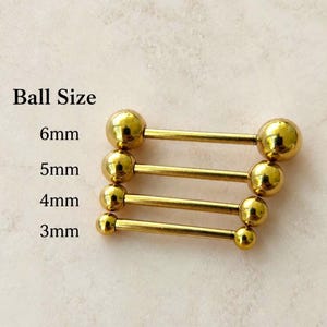 Puede incluir: Cuatro piezas de joyería corporal tipo barra recta en tono dorado con extremos esféricos. Las etiquetas de texto indican tamaños de bola de 6mm, 5mm, 4mm y 3mm. Las barras están dispuestas horizontalmente, mostrando una progresión de diámetros.