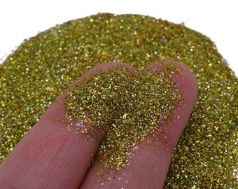 May include: A close-up of fine gold glitter with iridescent shimmer. The glitter is loose and has a fine texture.