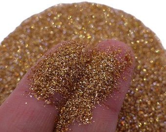 May include: A close-up of a pile of fine gold glitter. The glitter is very sparkly and has a metallic sheen.