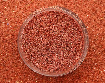 May include: A close-up of a glass jar filled with fine copper glitter. The glitter is a shimmery, metallic copper color.
