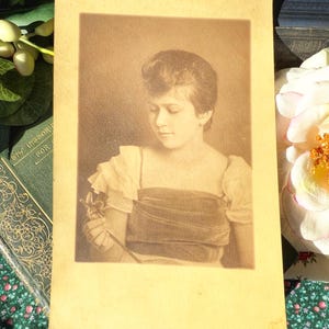Antique photograph of young girl holding a flower