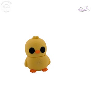 May include: A yellow chick figurine with large black eyes and an orange beak and feet. The chick has a round body and a small tuft of feathers on its head. The figurine is a 3D printed item.