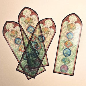 May include: Five colourful stained glass bookmarks with a geometric pattern and a series of circular designs. The bookmarks are in shades of green, blue, orange, yellow, and red.