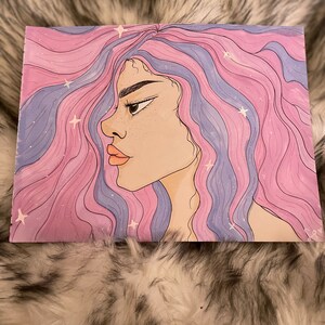 Puede incluir: Una ilustración digital de una persona con el pelo largo, rosa y morado que fluye con estrellas blancas. La persona está mirando hacia un lado con una expresión seria.