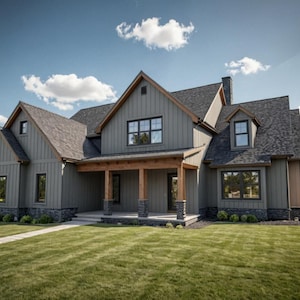 May include: A large, two-story house with a gray exterior, dark roof, and a covered porch. The house has multiple windows and a well-manicured lawn. The sky is blue with fluffy white clouds.
