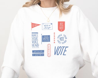 May include: White sweatshirt with a blue and red graphic print that says "Vote" and includes phrases like "Make your voice heard" and "Your vote counts".