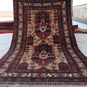 May include: A traditional Persian rug with a cream background and intricate red, blue, and green patterns. The rug has a fringe border and features a central medallion with a floral design.