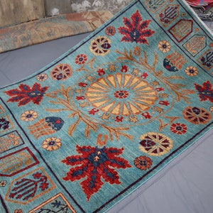 May include: A teal blue rug with a traditional Persian design. The rug features a central medallion with a floral pattern and a border with repeating motifs.