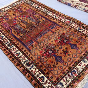 May include: A traditional Turkish rug with a detailed floral pattern in shades of red, blue, and white. The rug has a fringe border and is woven with intricate details.
