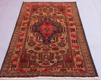 May include: Rectangular, hand-knotted rug with a central medallion design. The rug features a rich color palette of red, navy blue, and beige, with intricate floral and geometric patterns. The rug's dimensions are approximately 60 inches by 36 inches.
