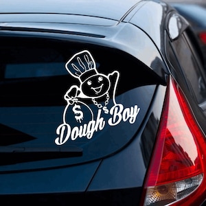May include: White vinyl sticker of a cartoon chef character holding a bag of money with the text "Dough Boy" on a black car.
