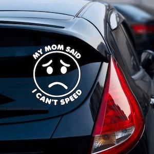 May include: White vinyl car sticker with a sad face and the text "My Mom Said I Can't Speed".