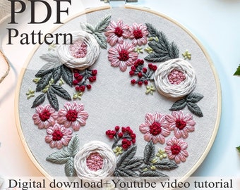 May include: A PDF pattern for a floral embroidery hoop art project. The design features pink and white flowers, green leaves, and red berries. The pattern includes a YouTube video tutorial.