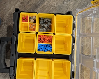 Puede incluir: Una caja de almacenamiento de plástico amarilla con múltiples compartimentos. Los compartimentos contienen varios conectores eléctricos, tuercas para cables y otras piezas pequeñas. La caja está abierta y los compartimentos son visibles.