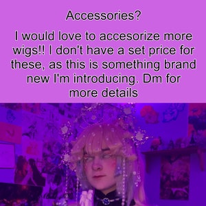 May include: A person wearing a light pink wig with a pearl and crystal crown. The wig is styled with bangs and side swept layers. The person is wearing a black choker with a blue jewel. The background is a purple wall with various posters and decorations.
