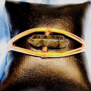 Mässingskopparmanschett med svart fasetterad kristall i mitten