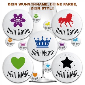Könnte beinhalten: Ein Set aus zehn runden weißen Knöpfen mit verschiedenen farbigen Designs. Die Designs beinhalten eine Blume, eine Krone, ein Einhorn, ein Herz, einen Stern und eine Vielzahl anderer Formen. Jeder Knopf hat den Text "Dein Name" aufgedruckt.
