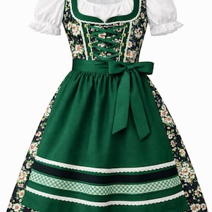 Op de afbeelding: Een traditionele groene dirndl jurk met een witte blouse en bloemaccenten. De jurk heeft een groene schort met decoratieve linten en een strik. Het lijfje is geregen en de rok is versierd met een bloemenpatroon.