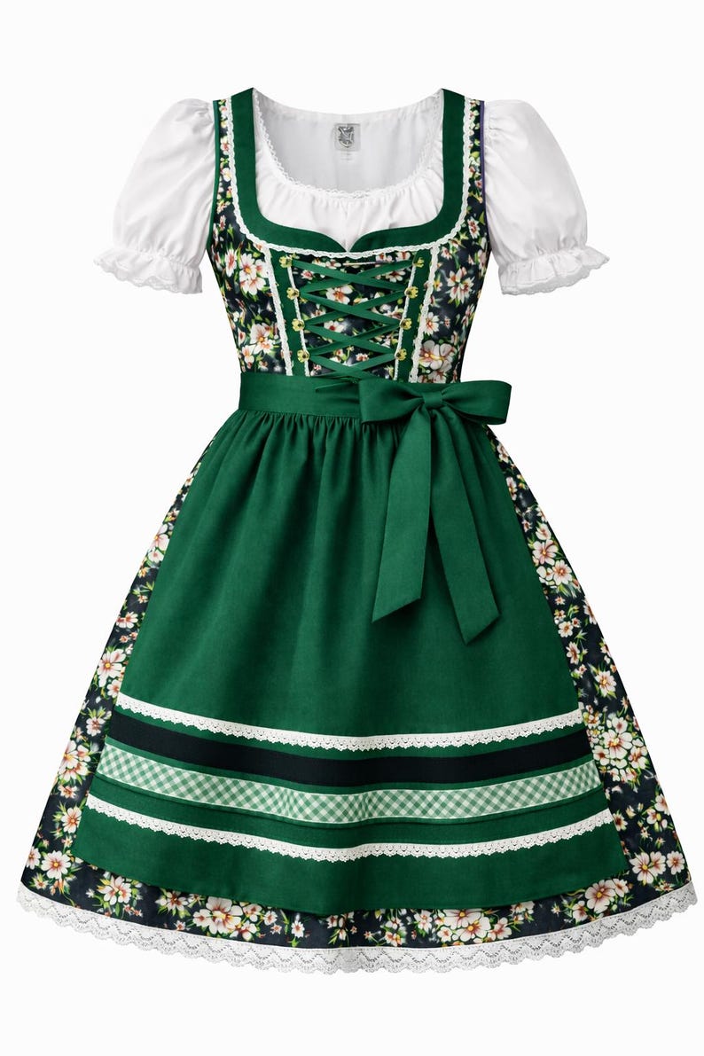 Op de afbeelding: Een traditionele groene dirndl jurk met een witte blouse en bloemaccenten. De jurk heeft een groene schort met decoratieve linten en een strik. Het lijfje is geregen en de rok is versierd met een bloemenpatroon.