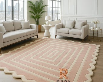 Puede incluir: Una alfombra rectangular grande con borde festoneado. La alfombra presenta un diseño geométrico con rayas alternas de rosa claro y blanco roto. La alfombra está en una sala de estar con muebles de color claro y grandes ventanas.