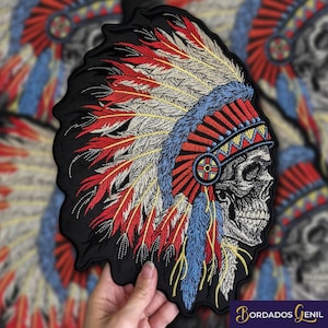 May include: Embroidered patch featuring a skull wearing a colourful Native American headdress with red, white, blue and yellow feathers. The patch is on a black background.