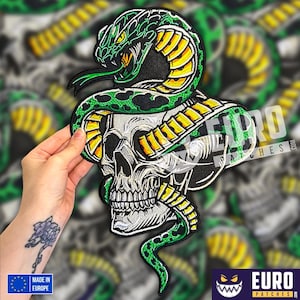 May include: Embroidered patch depicting a skull entwined by a green and yellow snake. The snake's head is at the top, tongue extended. The patch includes the text "EURO PATCHES" and "MADE IN EUROPE".