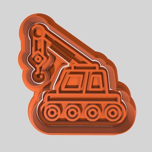 May include: Orange plastic cookie cutter shaped like a construction crane. The crane has a long arm with a hook at the end and a cab with four wheels.