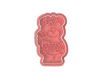 Puede incluir: Cortador de galletas de oso rosa con un lazo y una rosa. El oso sostiene un cartel que dice "MAMÁ".