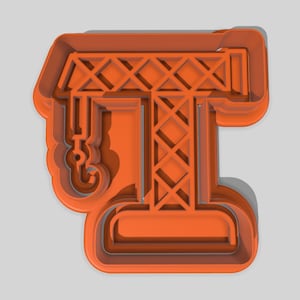 May include: Orange plastic cookie cutter shaped like a construction crane. The cutter features a hook, lattice boom, and a base. The crane is a single colour and has a shadow. The measurements are in centimetres.