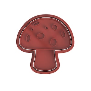 Puede incluir: Cortador de galletas de plástico rojo en forma de hongo con contorno blanco.
