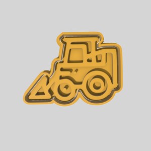 Puede incluir: Un cortador de galletas de metal amarillo con forma de tractor de carga frontal. El cortador tiene un diseño detallado con una pala, ruedas y una cabina.