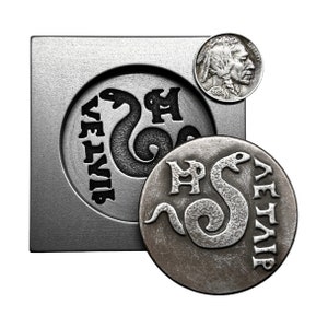 May include: A silver metal coin with a snake design and the text "VETIVIR" around the edge. The coin is sitting on a metal mold with the same design.
