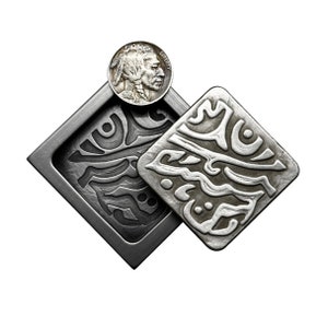 May include: Two square, silver-toned metal decorative pieces with intricate, swirling patterns. A vintage Buffalo nickel coin rests on one of the squares. The pieces have a rustic, antique appearance, set against a white background.