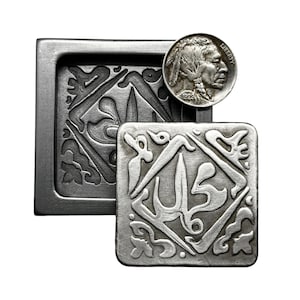 May include: A silver-colored metal box with a decorative design on the front. The box is open and a smaller silver-colored metal square with a similar design is inside. A silver-colored coin with a profile of a Native American man is on top of the box.