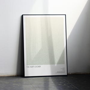 Może przedstawiać: Oprawiony wydruk artystyczny plakatu filmowego "The Hurt Locker". Plakat ma minimalistyczny design z jasną zielenią i białą kolorystyką. Plakat opiera się o białą ścianę.