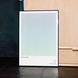 May include: A framed art print with a gradient of blue and green hues. The word "NETWORK" is printed in black at the bottom left. The print is displayed against a dark teal wall and a light wood panel.