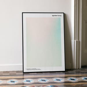a framed poster with a minimalist design, placed on a tiled floor next to a white door.