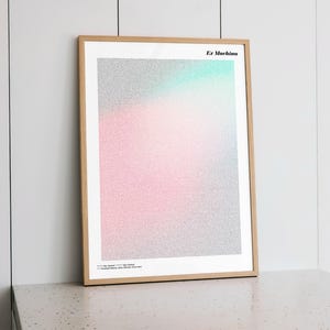 Puede incluir: Un cuadro enmarcado con un diseño degradado en tonos rosa, plateado y turquesa. La impresión se titula "Ex Machina" y tiene texto en la parte inferior. El marco es de madera clara.