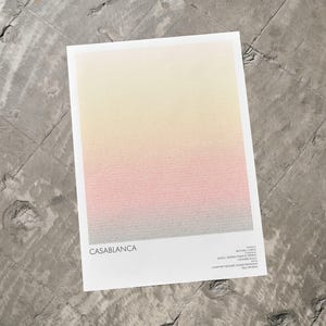 Pu&ograve; includere: Una stampa rettangolare con una sfumatura di colore, che passa dal giallo in alto al rosa e poi al grigio in basso. La parola "CASABLANCA" &egrave; stampata in nero in basso a sinistra.
