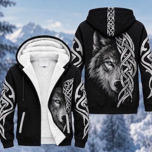 May include: A black zip-up hoodie featuring a white sherpa fleece lining. The exterior displays a detailed wolf face graphic on the front and back, accented by intricate white Celtic-style knotwork patterns along the sleeves and hood.
