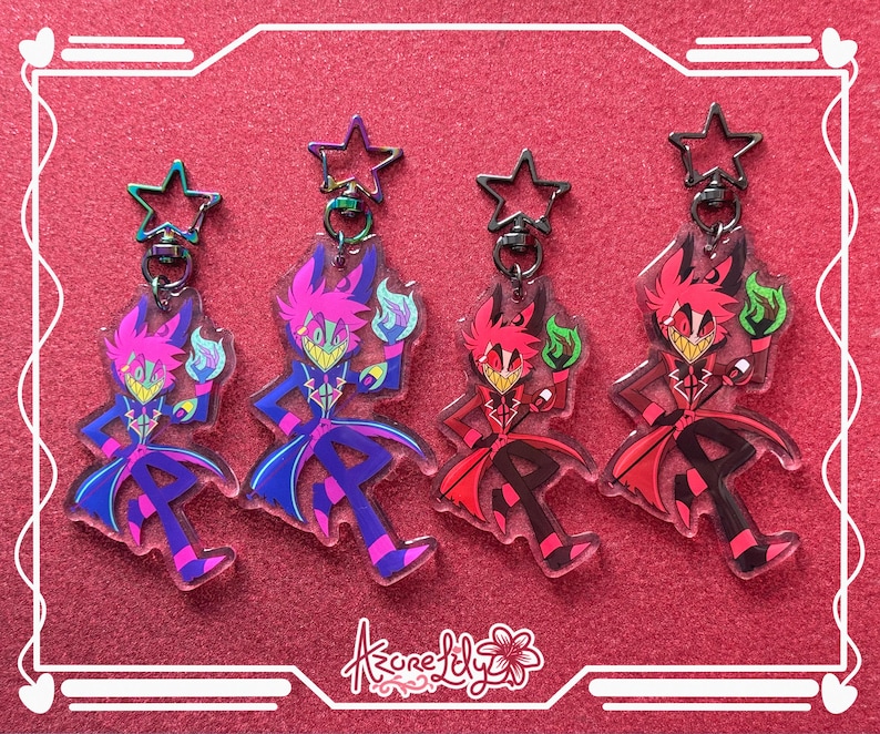 May include: Four acrylic keychains featuring a cartoon character with a wide grin, holding a flame. The keychains have star-shaped clasps and come in purple, blue, red, and black color schemes. The background is a textured red surface.