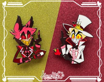 May include: Two enamel pins depicting cartoon characters. One pin is red and black, with a yellow, toothy grin. The other pin is white and red, with a yellow, toothy grin. Both pins are set against a gold and red background.