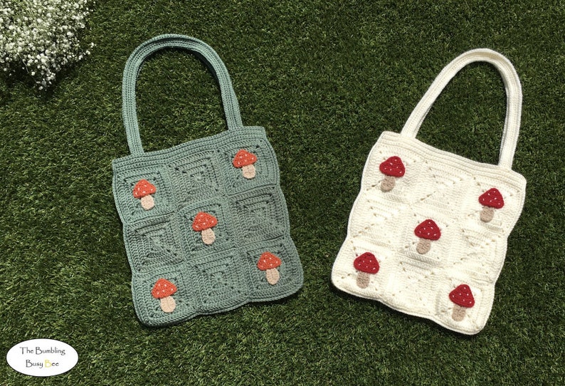 May include: Two crocheted tote bags with mushroom designs. One bag is green with red mushrooms and the other is white with red mushrooms.