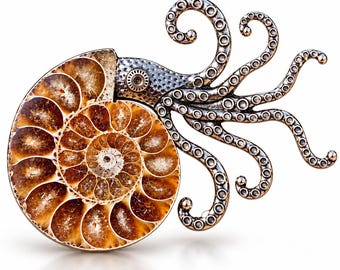 Könnte beinhalten: Eine Brosche mit einem polierten, braun-beigen spiralförmigen Ammoniten-Fossil, das an einem metallisch silberfarbenen Oktopuskopf mit Tentakeln befestigt ist. Der Oktopus-Teil zeigt eine strukturierte Oberfläche mit kreisförmigen Saugnäpfen.