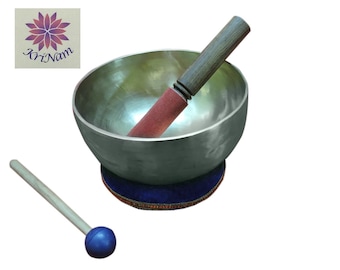 May include: A silver-colored singing bowl with a wooden and red mallet, resting on a blue cushion. A second mallet with a blue ball end is also present. The bowl has a logo in the upper left corner.
