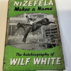 May include: A green book cover with white polka dots. The title is "NIZEFELA Makes a Name" in white letters. Below the title is a black and white photo of a horse jumping over a fence with a rider on its back. The text "The Autobiography of WILF WHITE" is in white letters on a green background.
