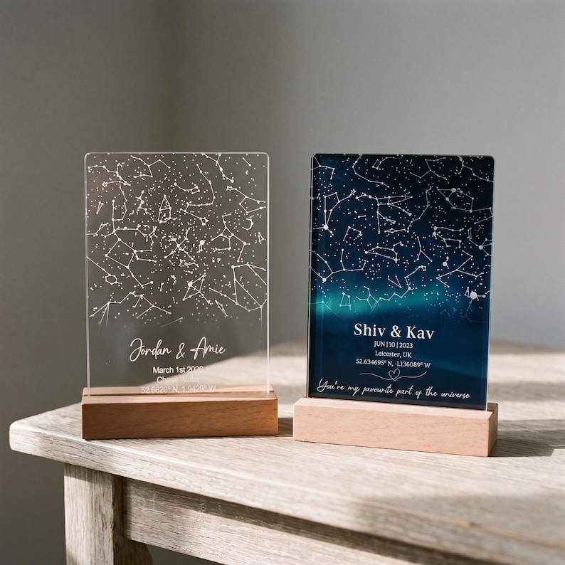 Puede incluir: Dos placas rectangulares de acr&iacute;lico sobre bases de madera clara. La placa izquierda es transparente con constelaciones blancas y el texto Jordan & Amie March 1st 2020. La placa derecha muestra un cielo nocturno azul oscuro con constelaciones.
