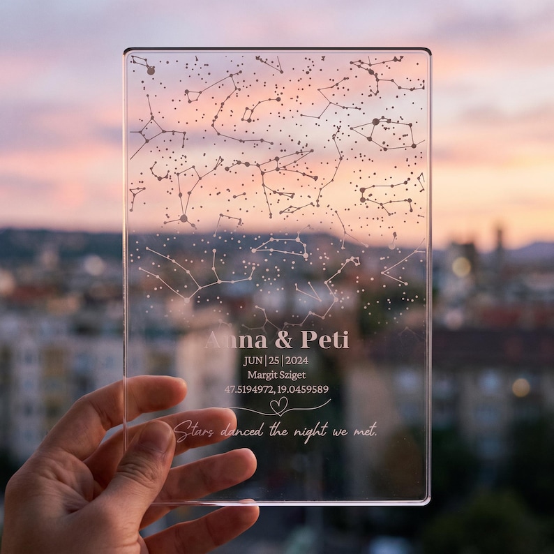 Puede incluir: Una placa rectangular de acr&iacute;lico transparente con un mapa estelar impreso. El texto dice Anna & Peti, JUN 25 2024, Margit Sziget, 47.5194972, 19.0459589, y Stars danced the night we met, junto a un peque&ntilde;o icono de coraz&oacute;n.